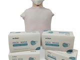 trois boîtes de masques faciaux et une tête de mannequin sur fond blanc