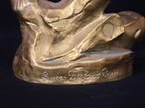 a gold statue of a man sitting on top of a table