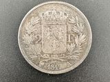 a silver coin with a coat of arms on it