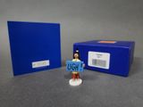 la figurine tient une pancarte sur laquelle on peut lire « ugh »