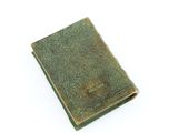 an old book with a green cover sitting on top of a table