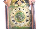 a green and gold clock with roman numerals on it