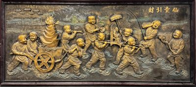 bronze relief of a group of people with a wagon