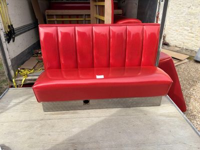 a red bench that is sitting in the back of a truck