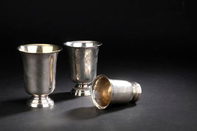 deux tasses en argent posées l'une à côté de l'autre sur une surface noire