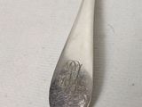 a silver spoon with a silver handle on a white surface