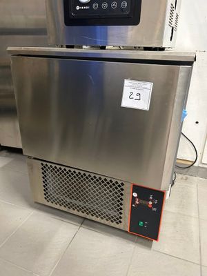 a stainless steel freezer sitting on the floor in a kitchen