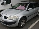 a silver car parked in a parking lot next to a white van