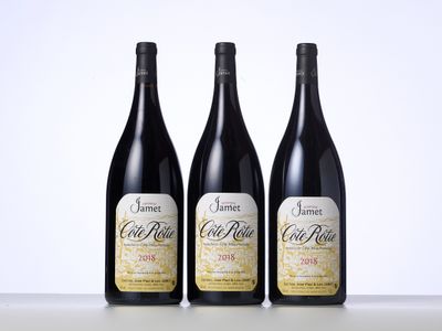 trois bouteilles de vin posées sur une table l'une à côté de l'autre