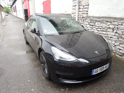 une Tesla noire garée au bord de la rue