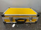 une vieille valise jaune et argent posée sur une table
