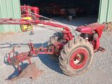 a red tractor that is parked in front of a building