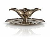an antique silver plate with a flower on it on a white surface