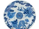 une assiette bleue et blanche ornée de deux poissons et de nuages