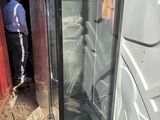 un homme debout près d'une porte vitrée dans un immeuble