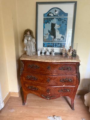 a picture of a dresser in a room with a painting on the wall