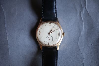 une montre posée sur une surface bleue