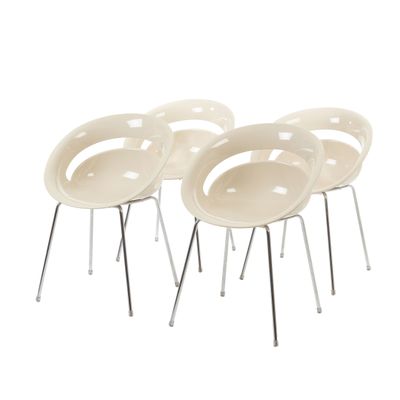 quatre chaises blanches aux pieds chromés et à l'assise blanche