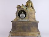 a statue of a woman sitting on top of a clock