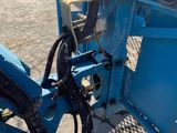 a blue machine that is sitting in the dirt