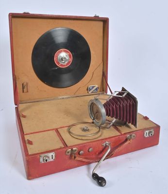 une valise rouge contenant un disque, posée sur une surface blanche