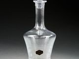 a clear glass bottle with a black label on it