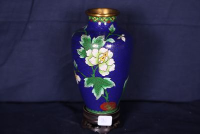 un vase bleu orné de fleurs blanches sur fond noir