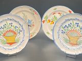 three plates with flowers painted on them sitting on a table