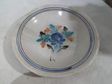 une assiette blanche ornée de fleurs bleues et orange