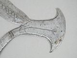 a silver knife that is laying on top of a table