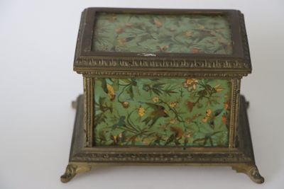 une petite boîte ornée d'un oiseau, posée sur une table