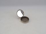 a small silver container with a coin inside of it