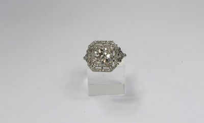 a white gold and diamond ring on a clear acrylic stand