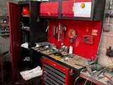 un établi rouge dans un garage, sur lequel sont posés des outils
