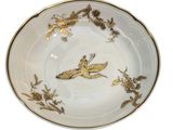 an image of a white plate with a gold bird on it