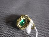 a close up of a ring with a green stone in it