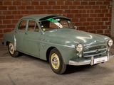 a green car parked in a garage with a brick wall in the background