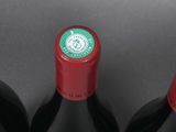 three bottles of red wine sitting on top of a table