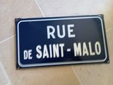un panneau indiquant « rue de Saint-Malo » posé au sol