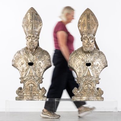 a woman walking past two statues of popes