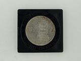 a close up of a coin on a white surface with a white background