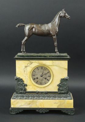 statue d'un cheval posée sur un socle en marbre, avec une horloge au centre