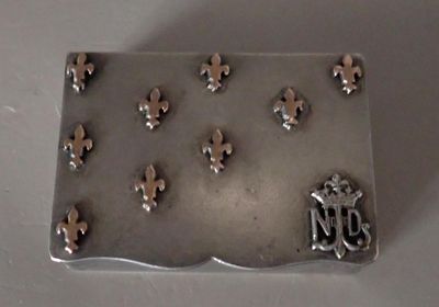 a metal plaque with fleurons on it on a table