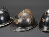 three helmets are lined up in a row on a gray surface
