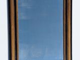un miroir accroché au mur, avec un ciel bleu en arrière-plan