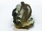 une figurine représentant une femme et un chien sur une feuille