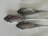 two spoons and a fork on a white table