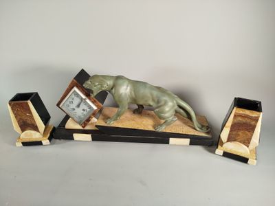 une statue de chat posée sur une table avec une horloge