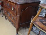 une commode en bois sur laquelle est posé un vase