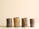 trois petits vases sont alignés sur une surface blanche